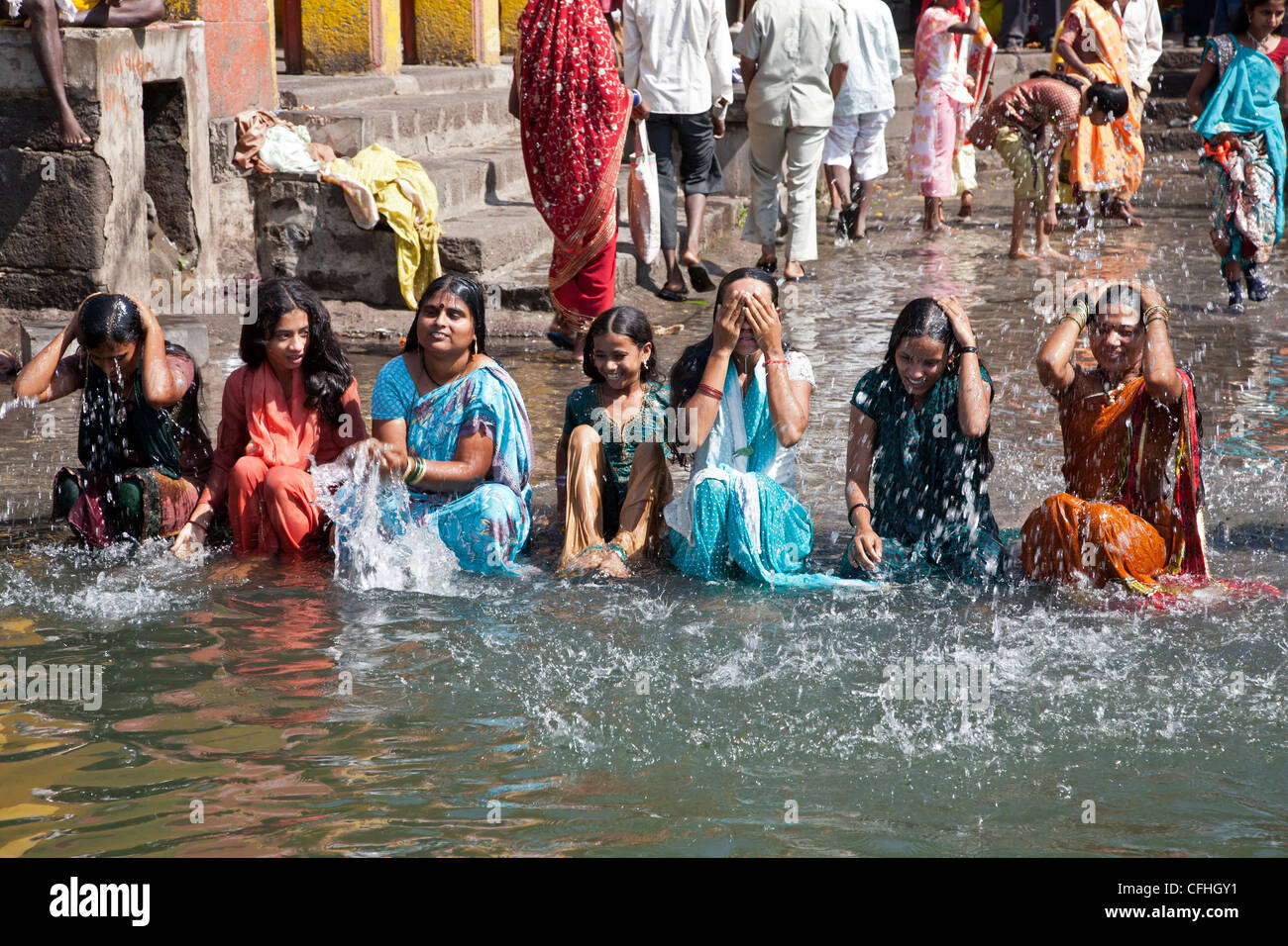 Young indian women bathing in the sacred waters of the Godavari river. Ram Kund. Nasik. India Stock Photo