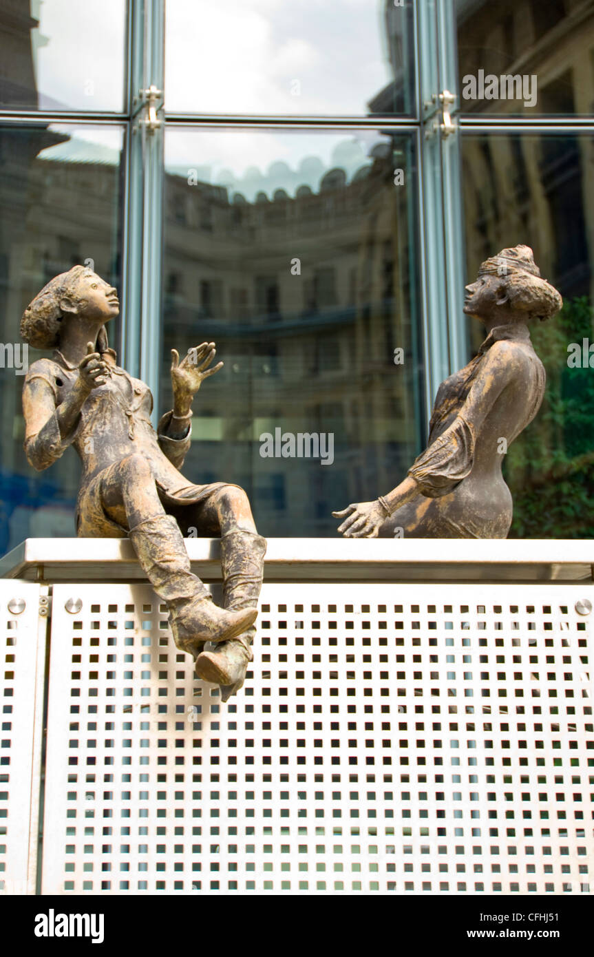Vertical close up of bronze sculptures of people sitting outside the Charlemagne Building in central Brussels, Belgium Stock Photo