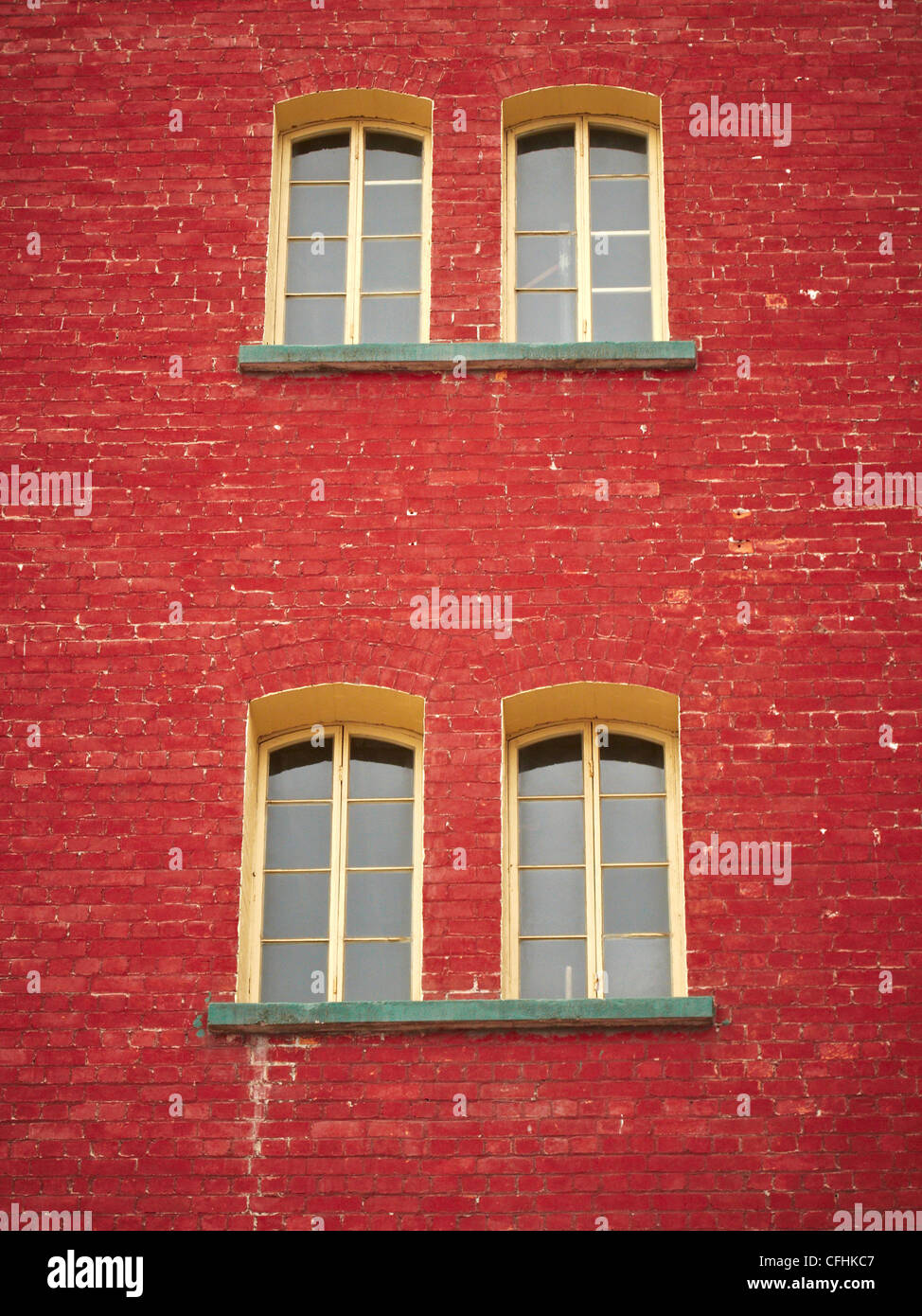 Old red brick building with four windows close together Stock Photo