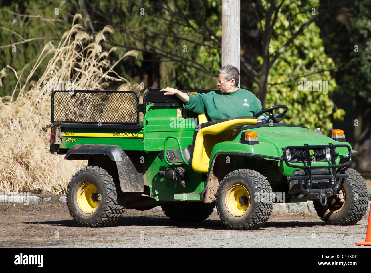 A woman gardener backing up her utility vehicle for a load of mulch. Stock Photo