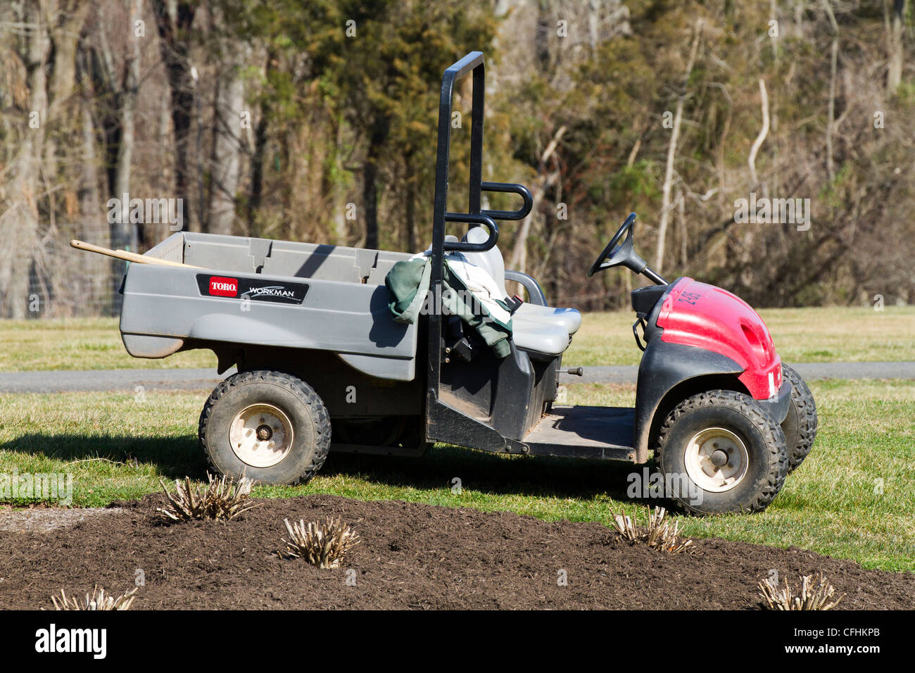 Toro utility vehicle in the garden next to flower bed covered in mulch. Stock Photo