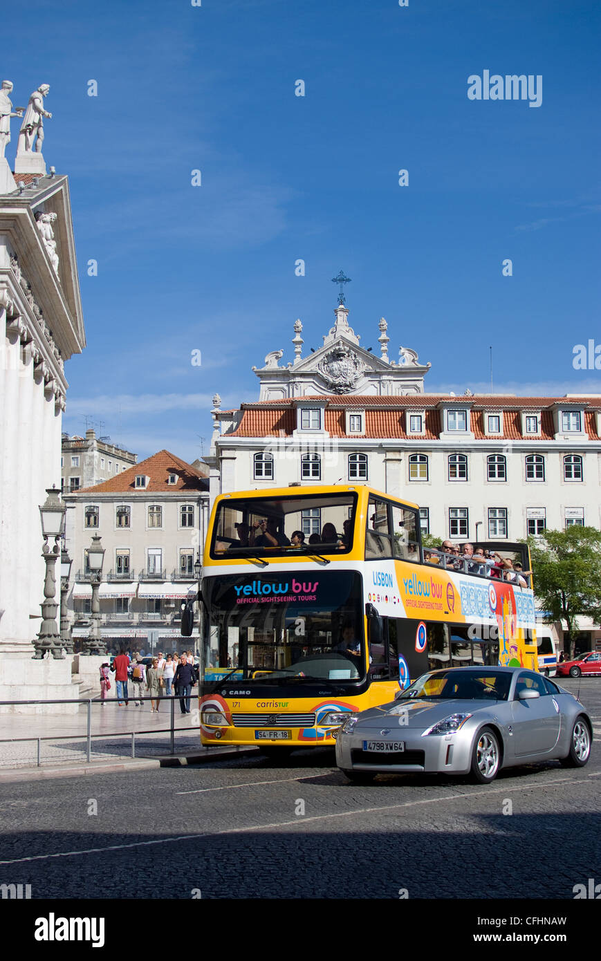 Lisbon Yellow Open Top Tourist Bus, going past National Theatre, Rossio Square, central Lisbon, Portugal, Europe Stock Photo