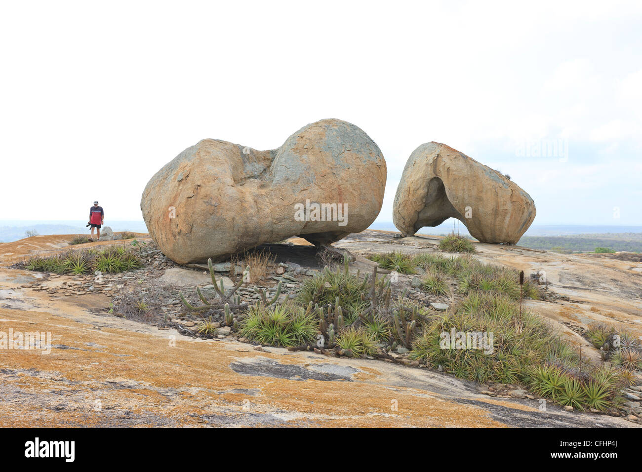 Man walking next to helmet shape boulders in Pai Mateus, Cabaceiras, Paraiba, Brazil, Brasil Stock Photo