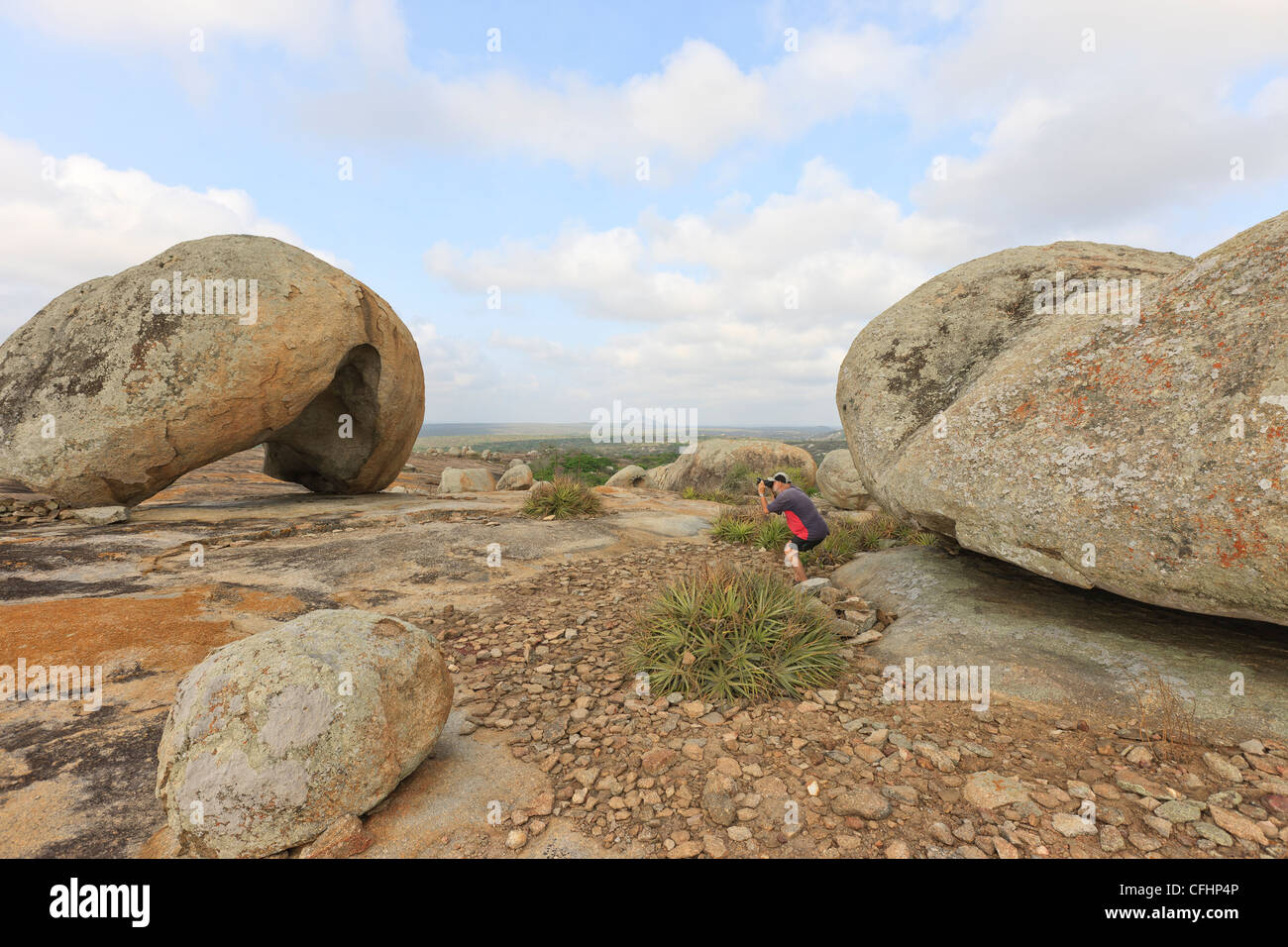 Man taking pictures of helmet shape boulder in Pai Mateus, Cabaceiras, Paraiba, Brazil, Brasil Stock Photo
