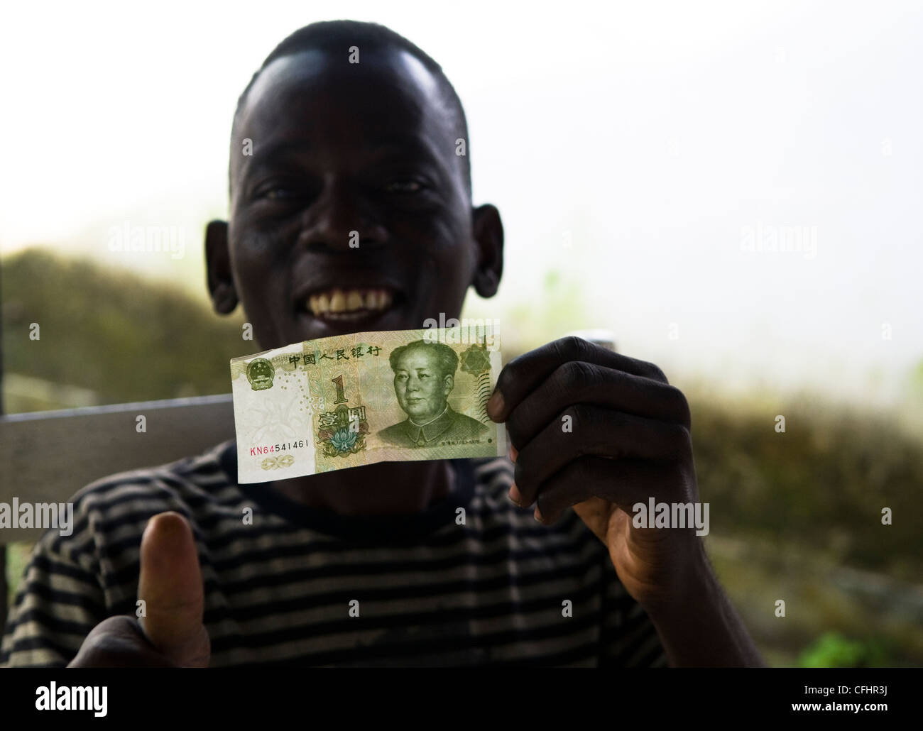 A Togolese boy holding a 1 RMB note. China has a strong presence in Africa building new infrastructure in return for resources. Stock Photo