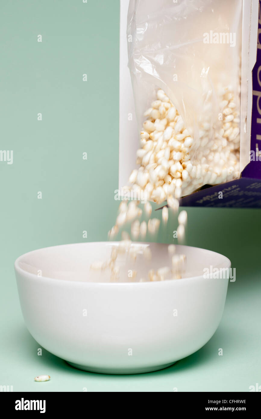 Puffed rice pouring into a white bowl Stock Photo
