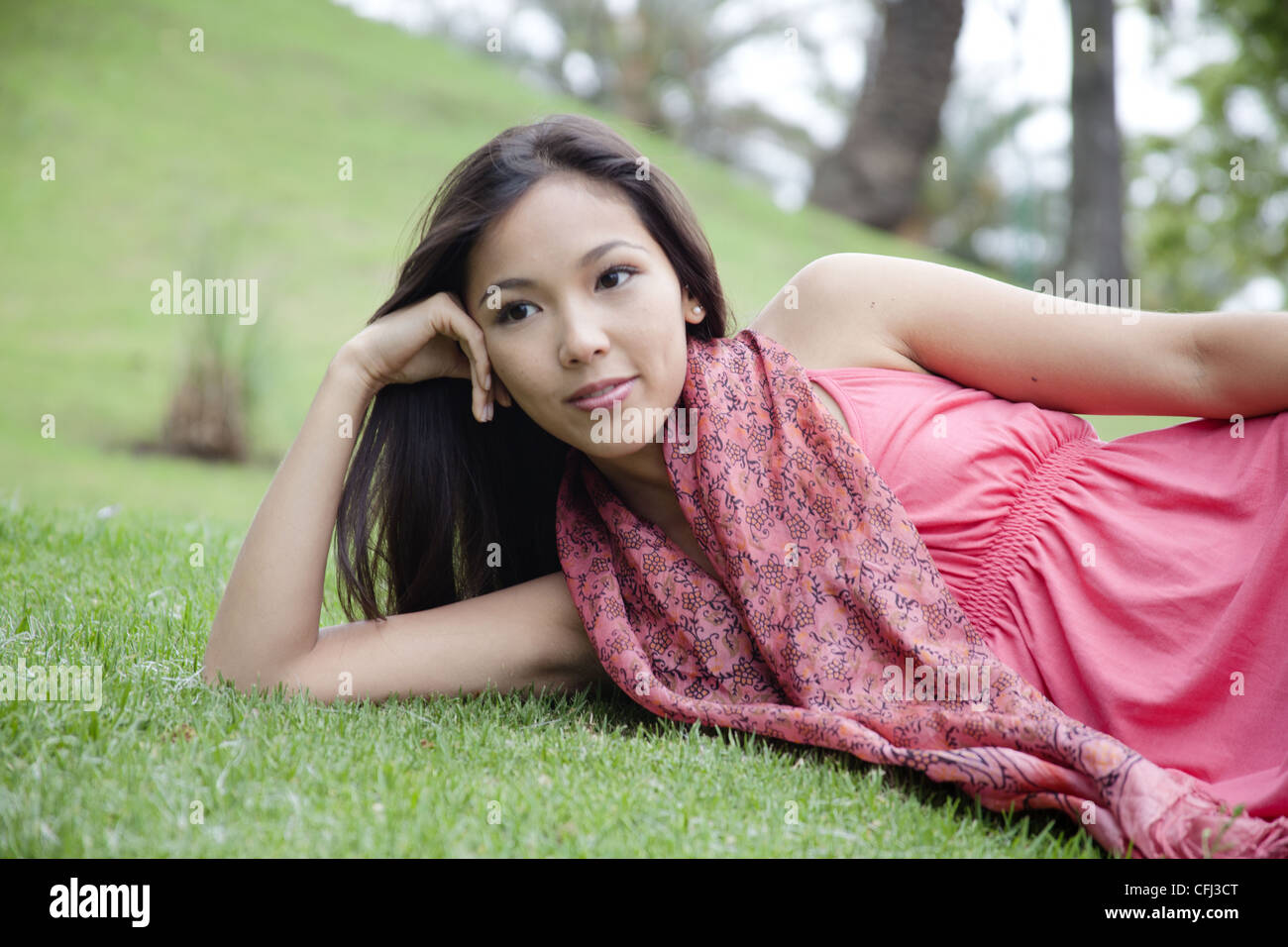 Young woman lying on grass Stock Photo - Alamy