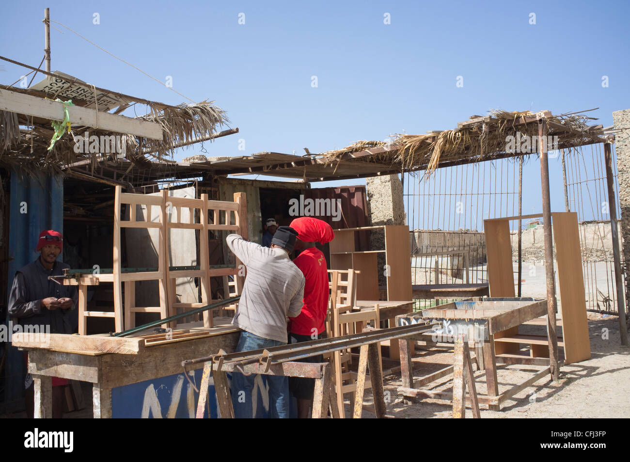 Sal Rei Boa Vista Cape Verde Three men working in a water side carpenters shop making wooden dining room chairs Stock Photo
