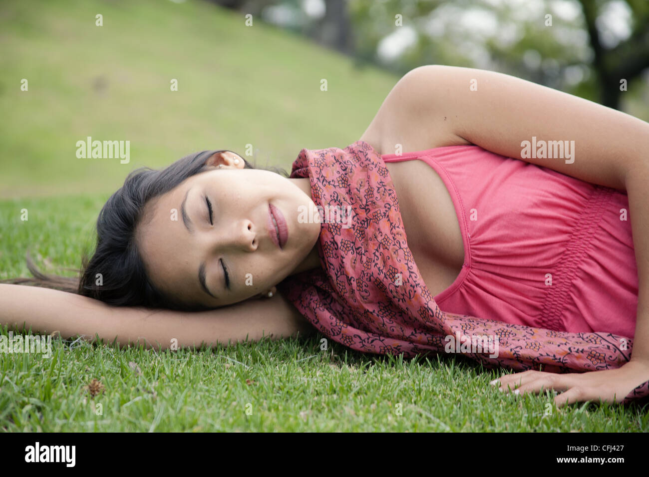 Young woman lying on grass Stock Photo - Alamy
