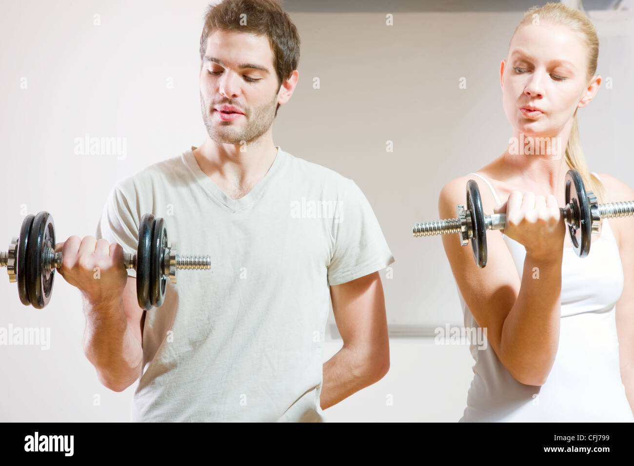man and woman lifting dumbbell in gym Stock Photo - Alamy