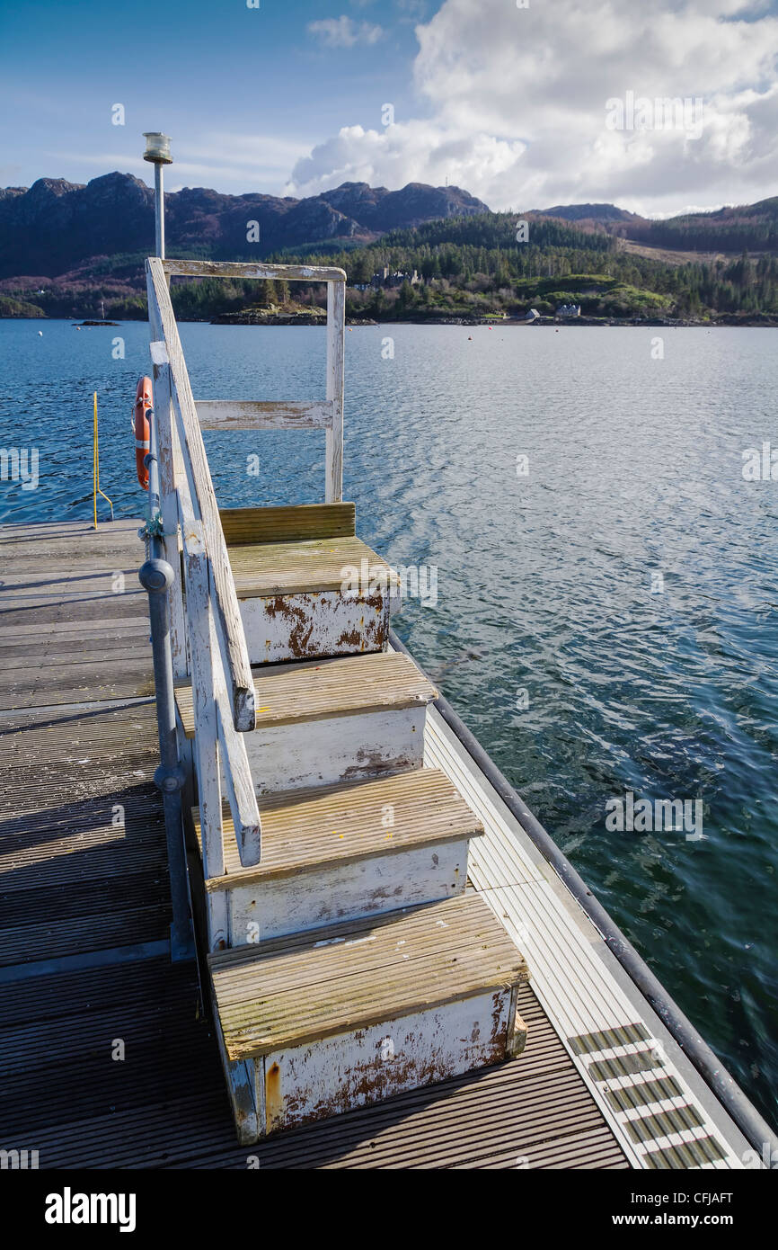 Wooden steps on floating pontoon in strong sunlight Plockton Bay
