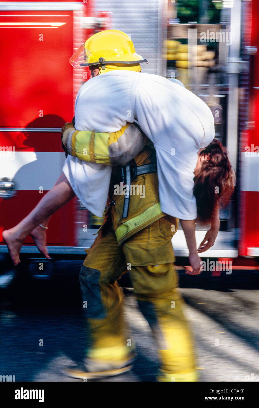 Fireman rescues unconscious woman from fire, USA  1997 Stock Photo