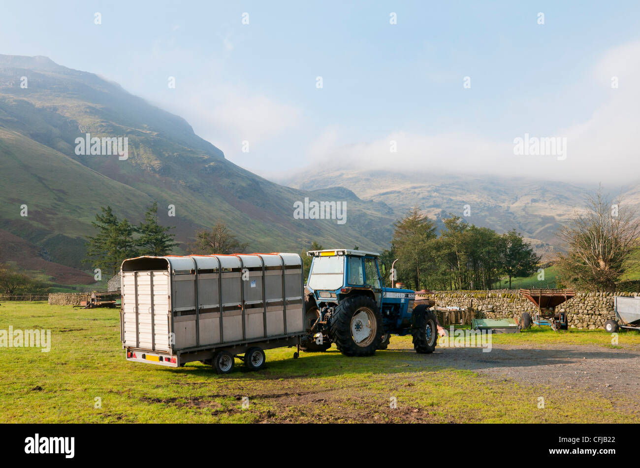 Tractor and livestock trailer on hill farm in Lake District, Cumbria, UK Stock Photo