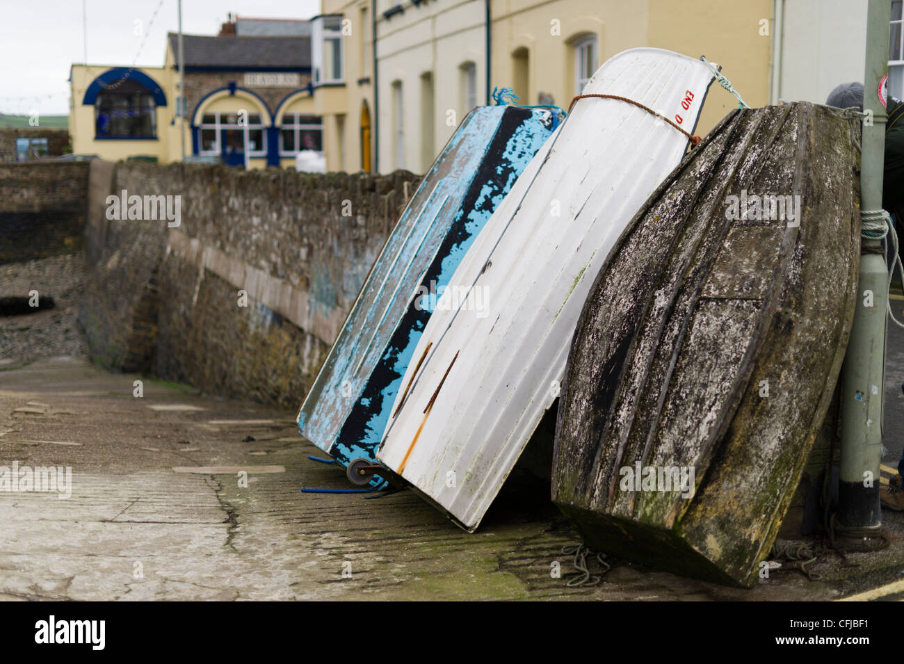 Boats stacked against a stone sea wall in Appledore Devon next to the river Taw Stock Photo