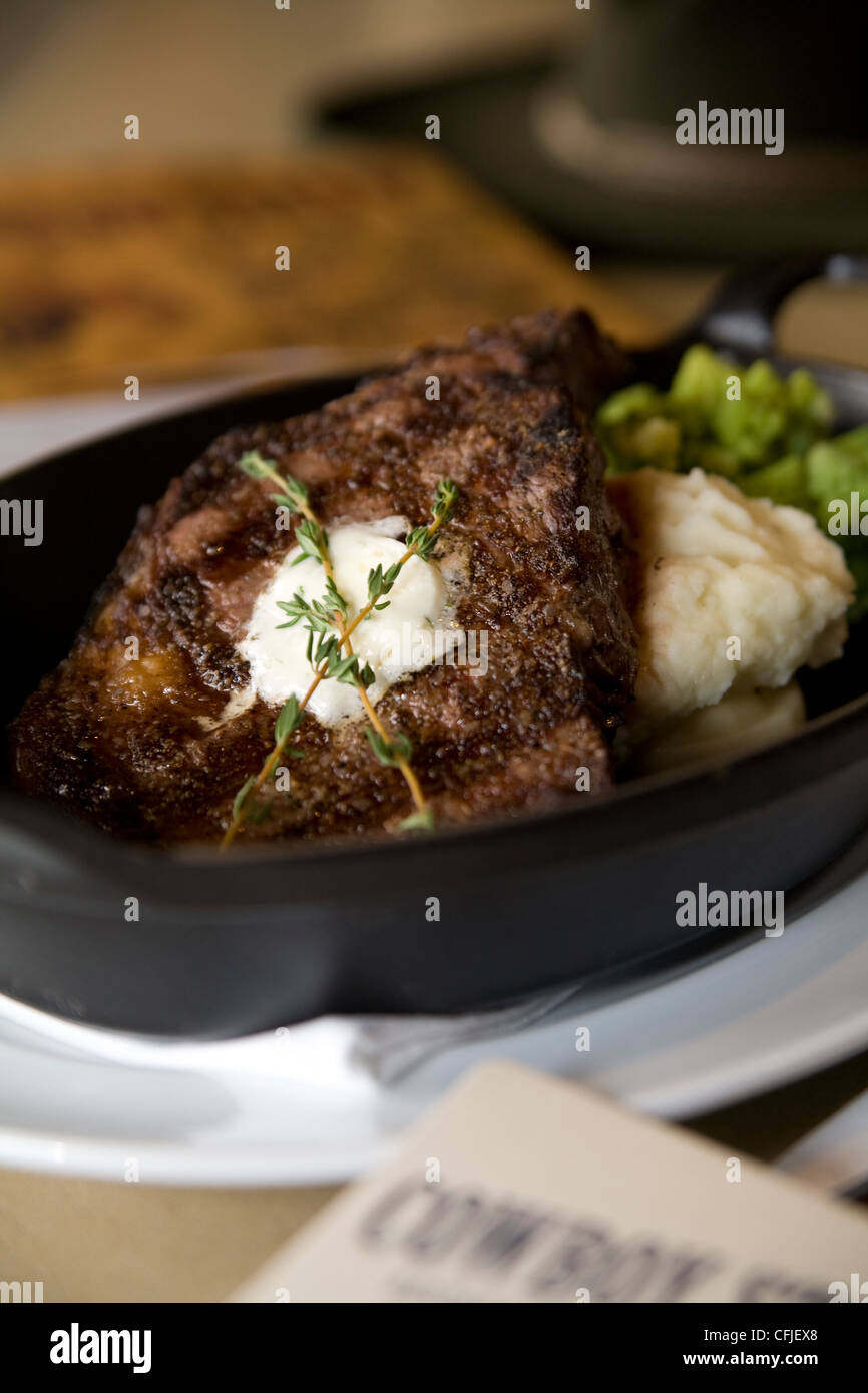 Sizzling TBone steak served in cast iron with mashed potatoes and