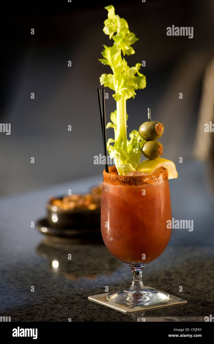 Classic Bloody Mary garnished with celery stick and stuffed olives