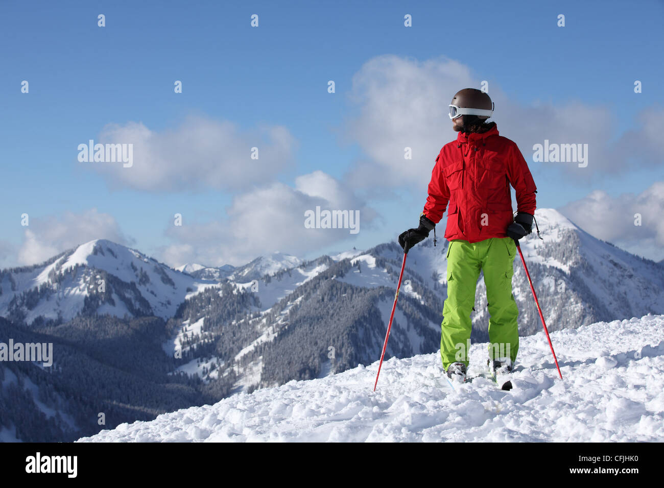 Skier taking in mountain scenery Stock Photo