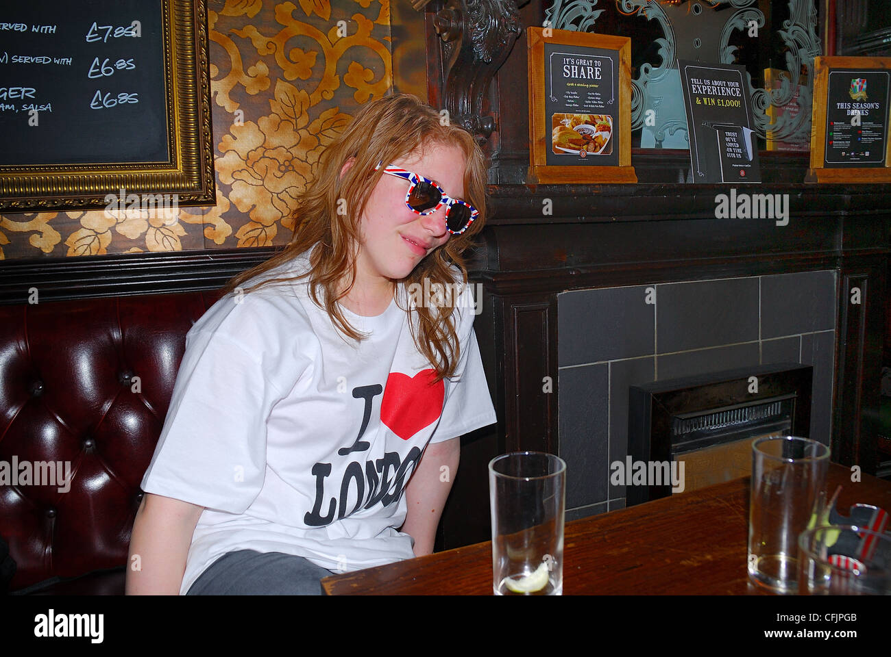 The Imperial Pub, London. It is a historic pub near Piccadilly Circus. A girlie sits at a table. Stock Photo