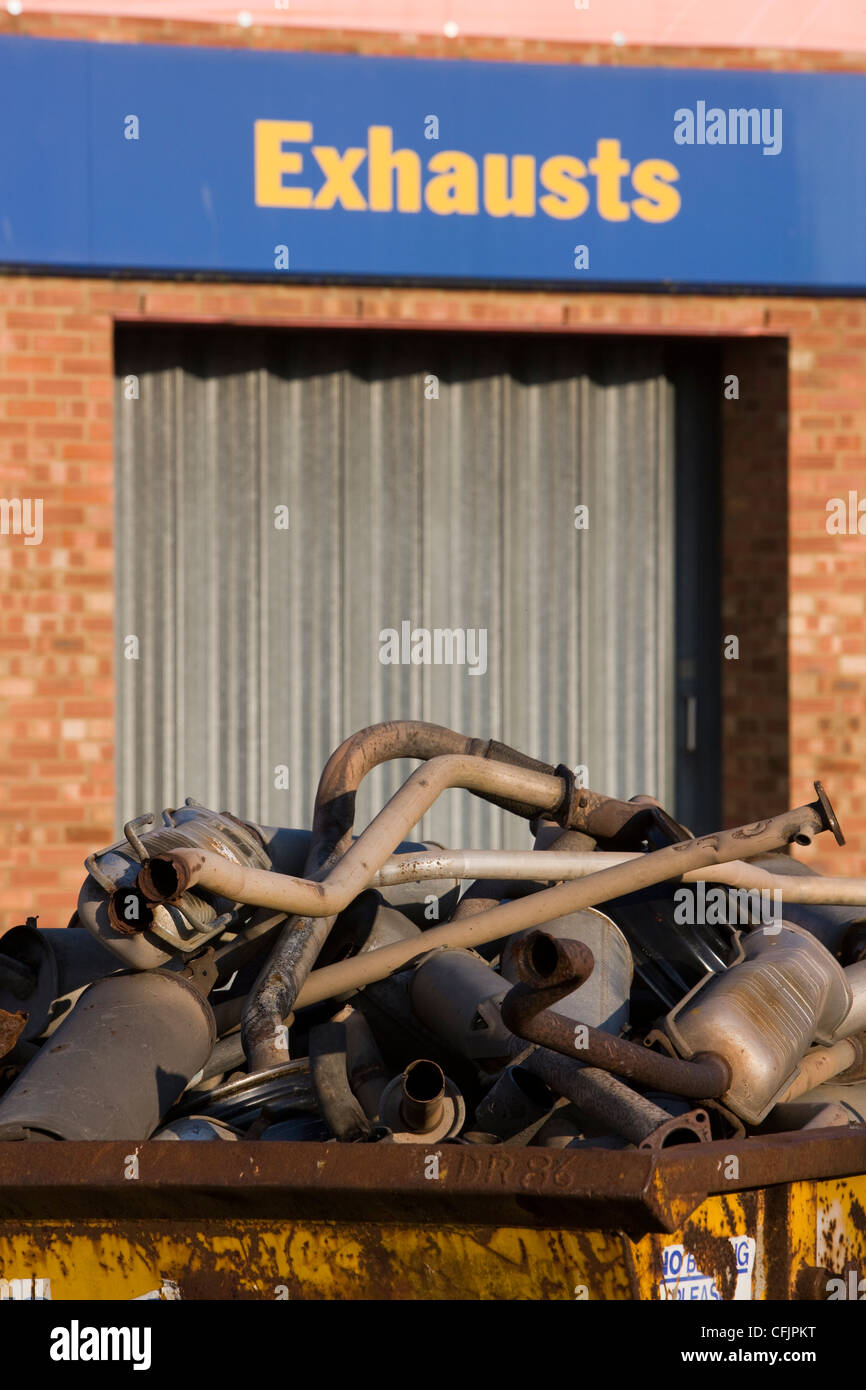 Pile of scrap metal car exhausts and silencers in a skip ready for