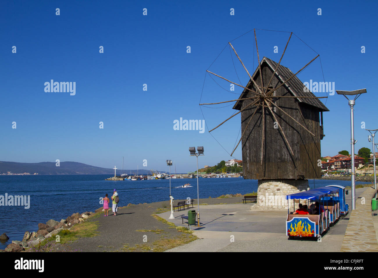 Historical wooden windmill on the Isthmus and small sightseeing tourist train, Nessebar, Black Sea, Bulgaria, Europe Stock Photo