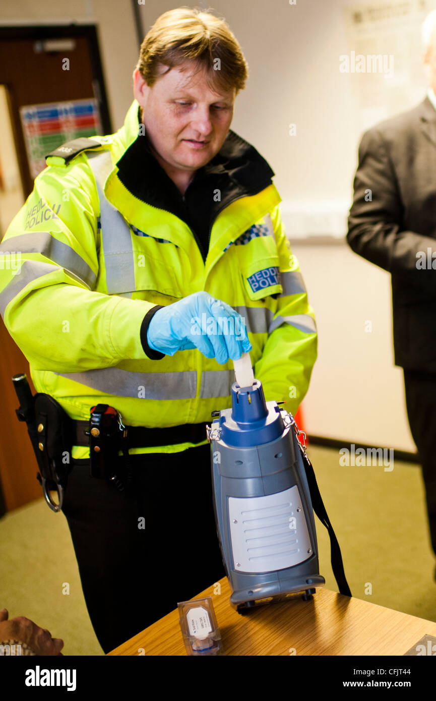 a uniformed police officer calibrating an SAFRAN morpho detection automatic drug testing device, UK Stock Photo