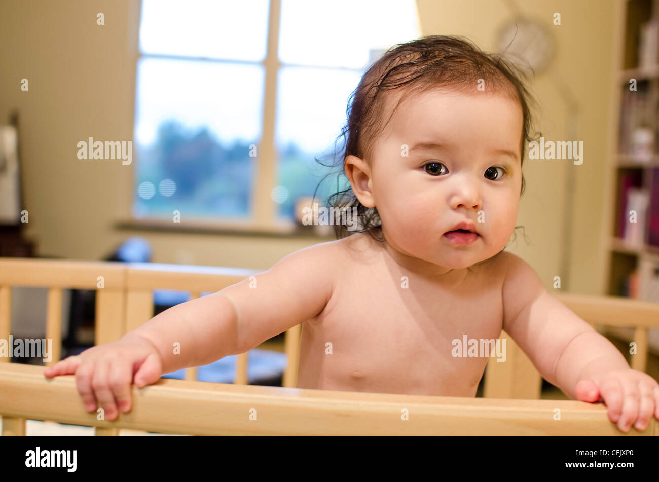 Cute baby girl in a crib. Mixed ethnicity (Asian, Caucasian) Stock Photo