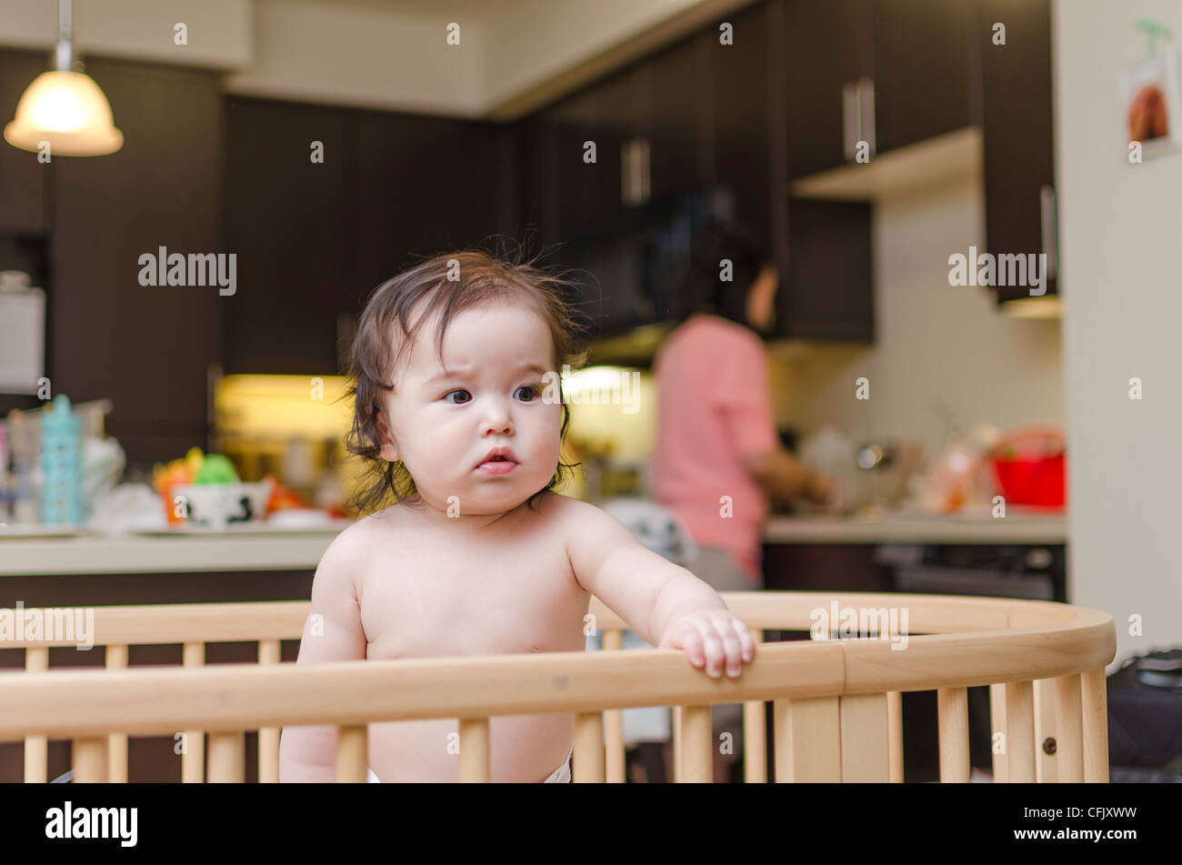 Cute baby girl in a crib. Mixed ethnicity (Asian, Caucasian) Stock Photo