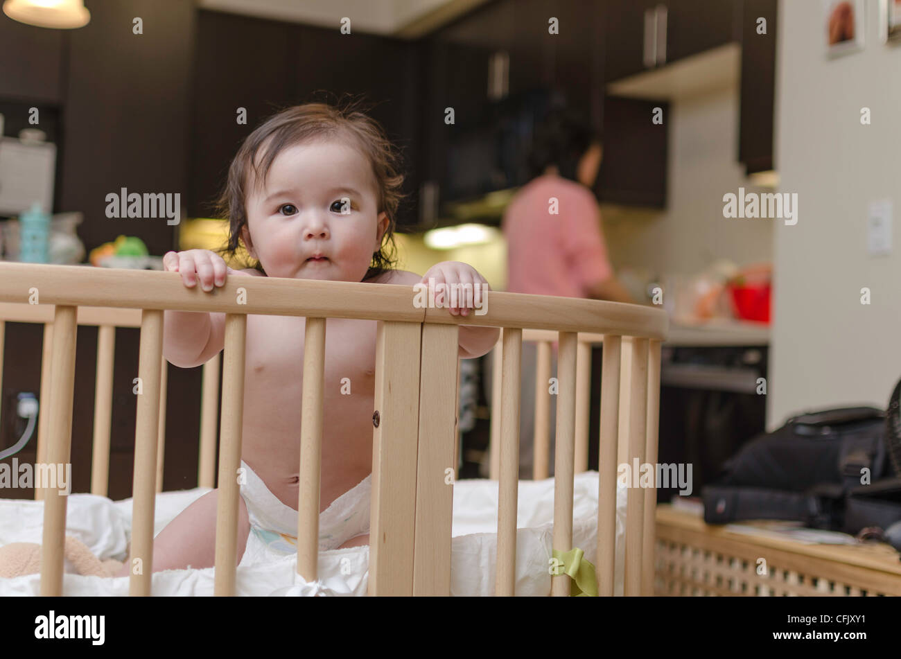 Cute baby girl in a crib. Mixed ethnicity (Asian, Caucasian) Stock Photo