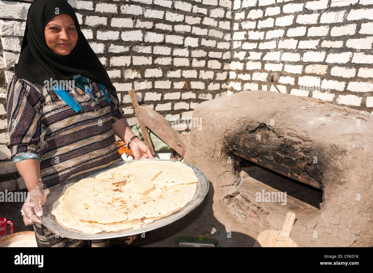 Woman with just made traditional Aich bread Minya Egypt Stock Photo
