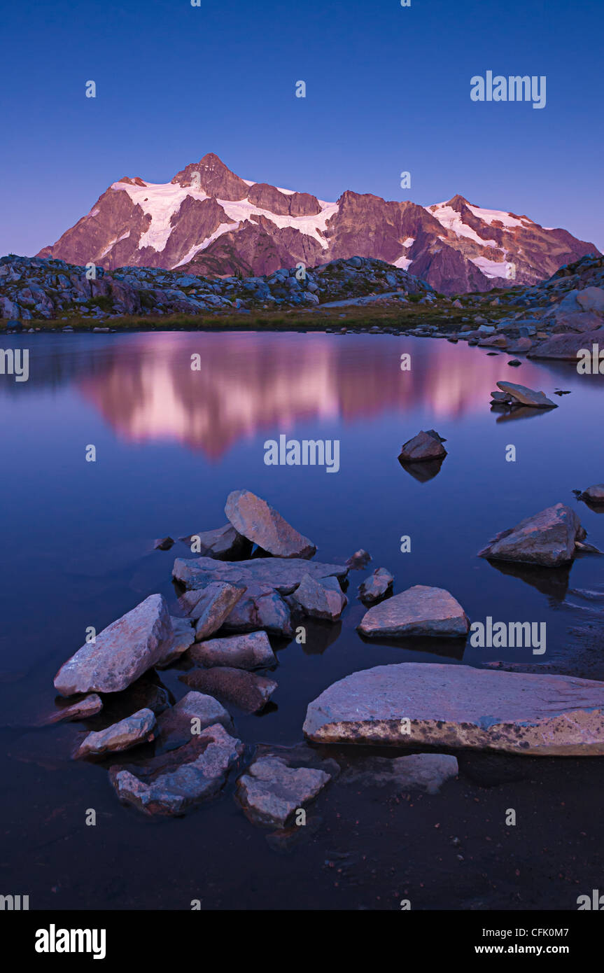 Mount Shuksan and reflection in tarn on Artist Ridge at dusk; Mount Baker-Snoqualmie National Forest, Washington. Stock Photo