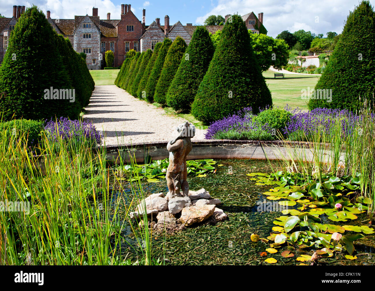 Ornamental pond,statue and topiary in the English country garden of