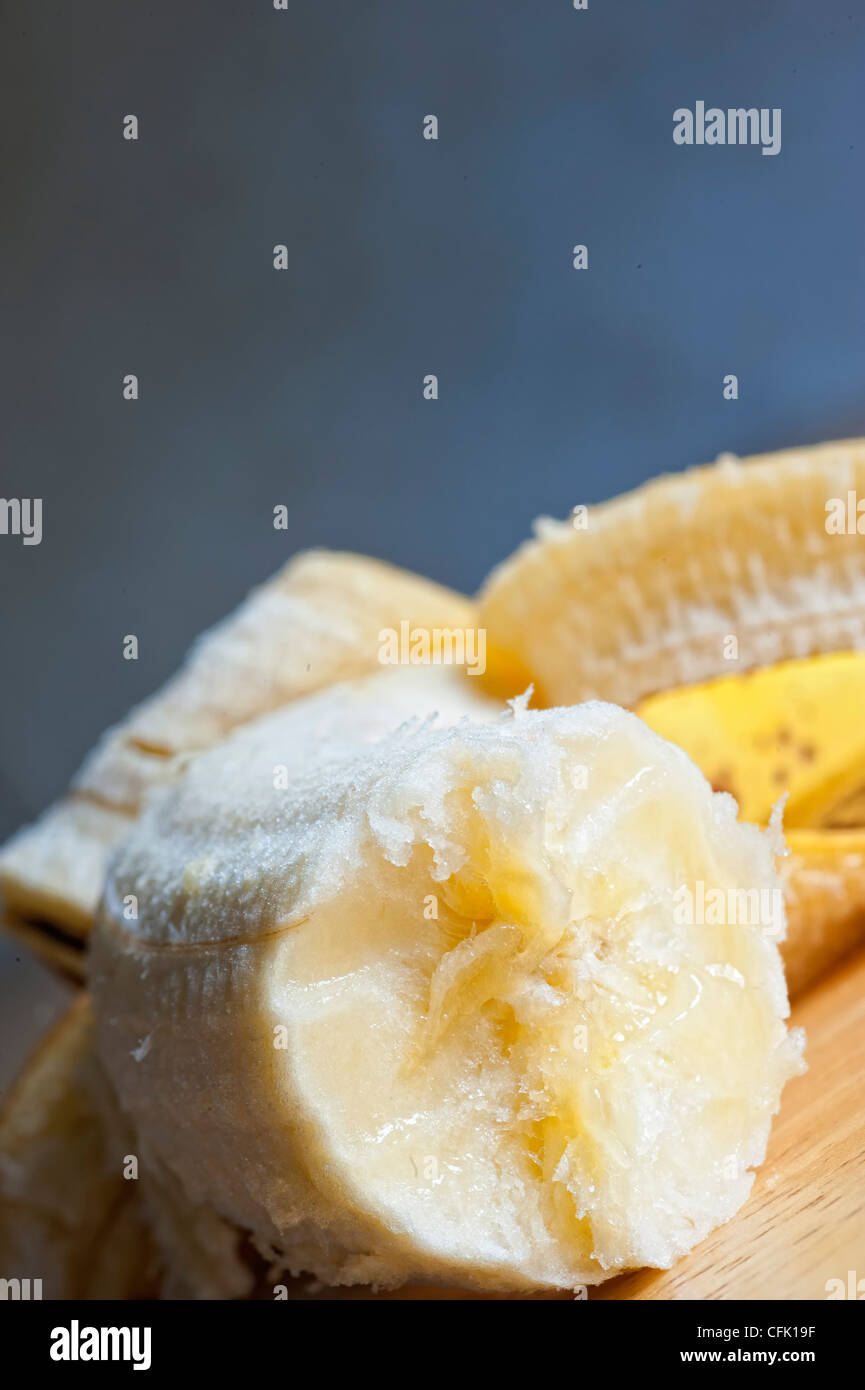 Peeled banana with bite Stock Photo