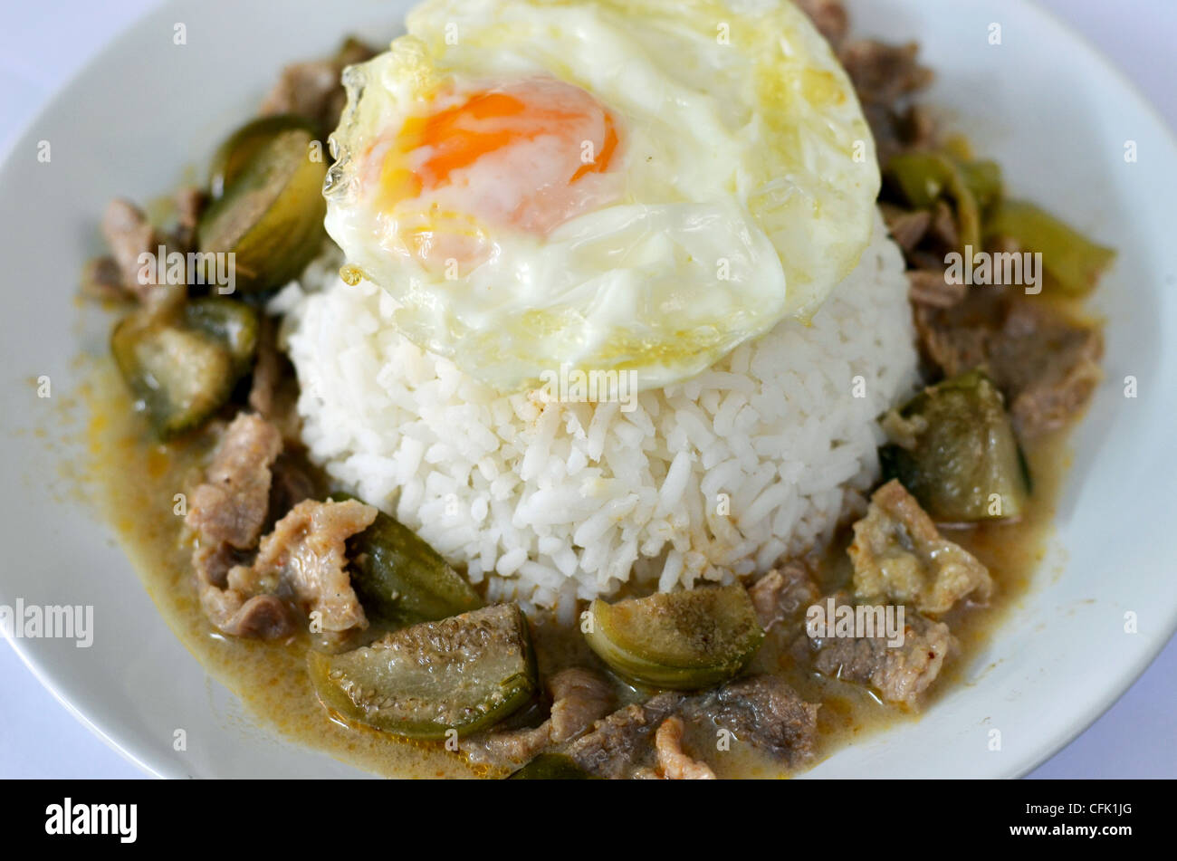 steamed rice served with fried eggs and beef in ground peanutcoconut