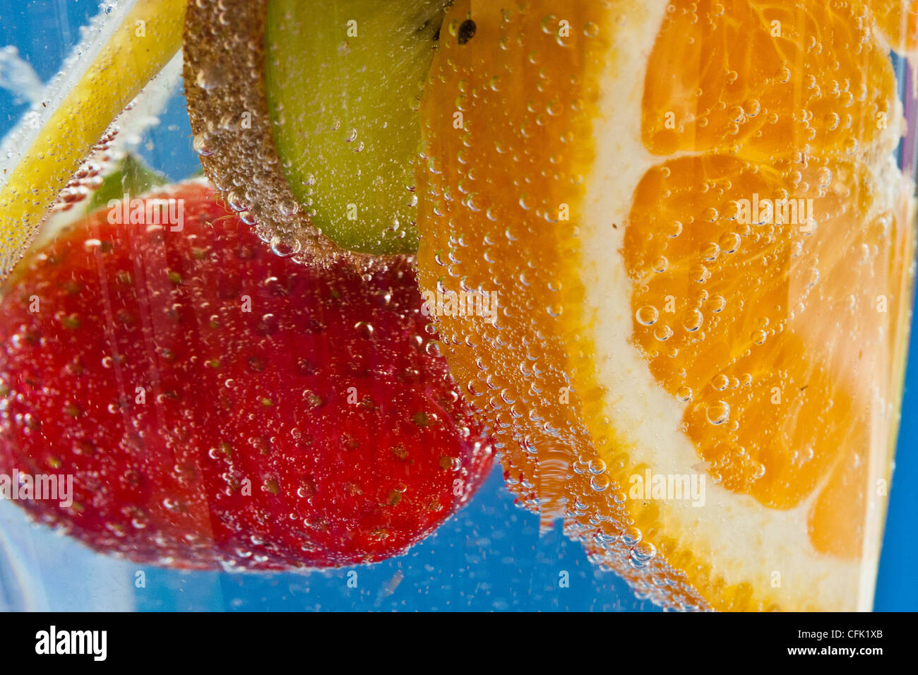 Fruit cocktail in fizzy soda water against an electric blue