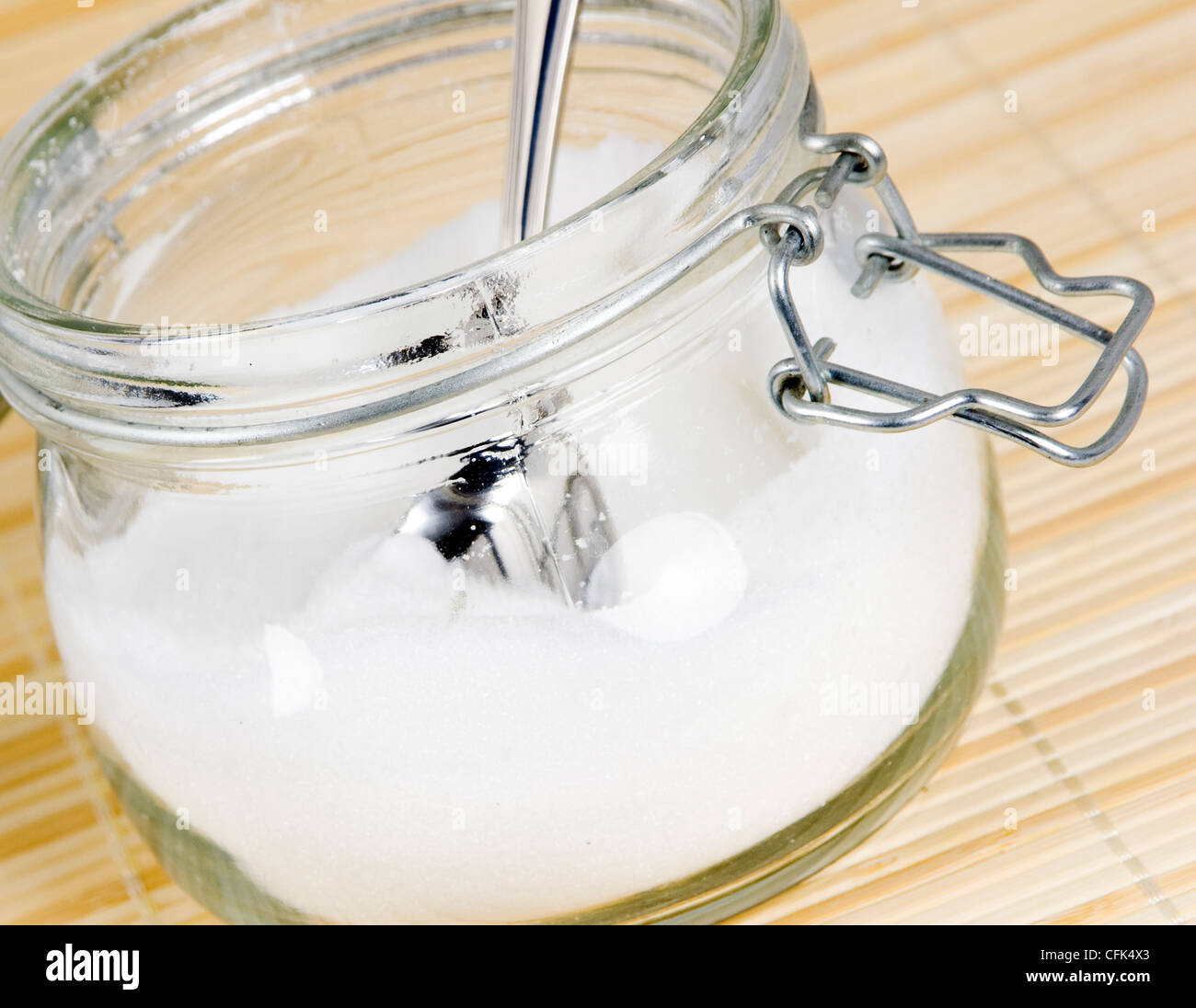 White sugar in glass jar with spoon Stock Photo