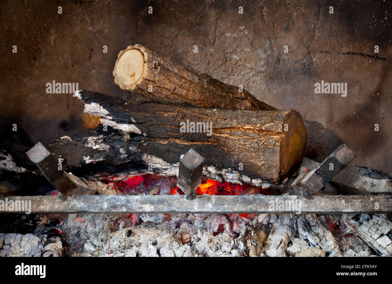 fireplace with burning wood logs on iron grate and ash Stock Photo