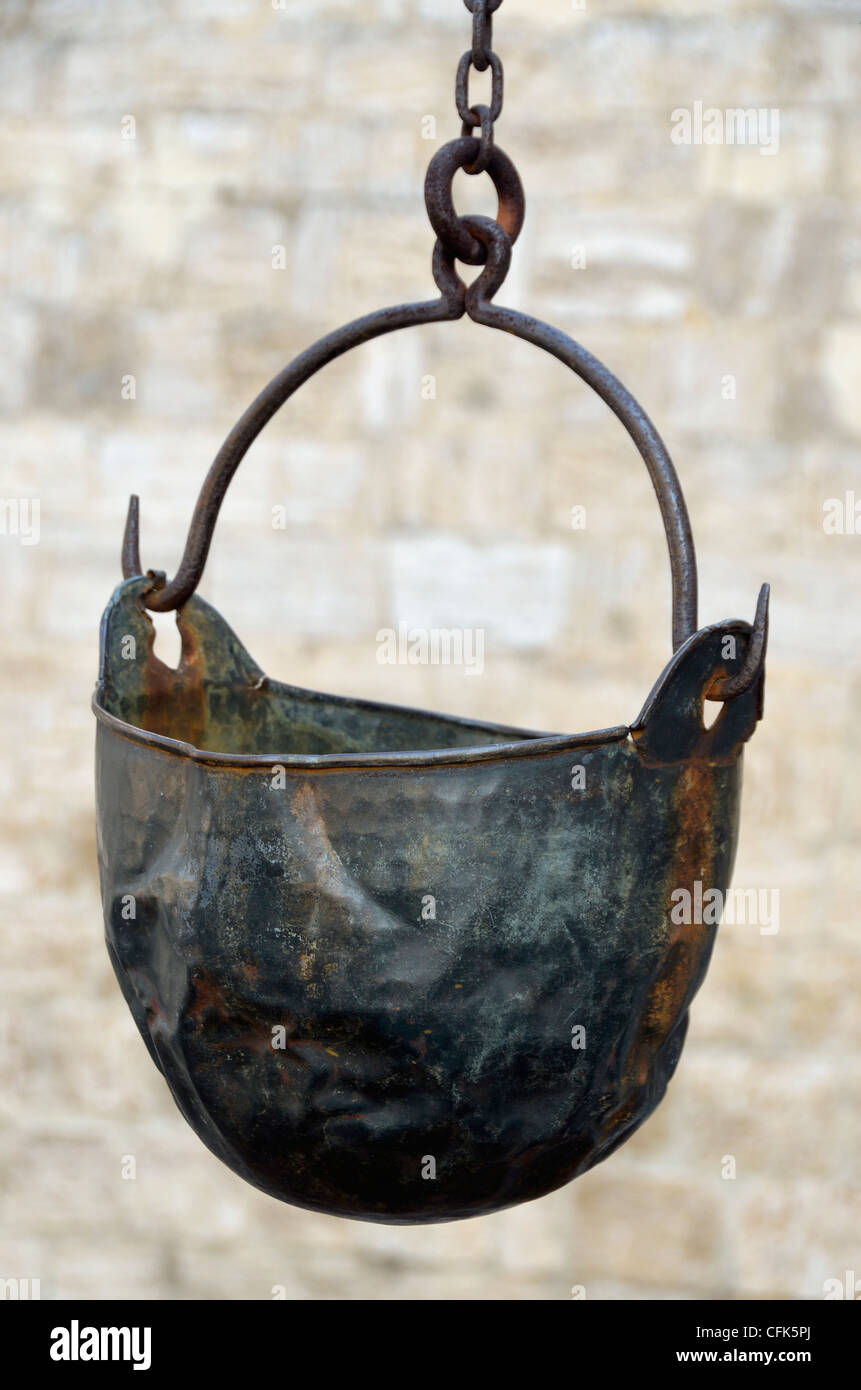 Old metal dipping bucket at well, San Quirico d'Orcia, Italy. Stock Photo
