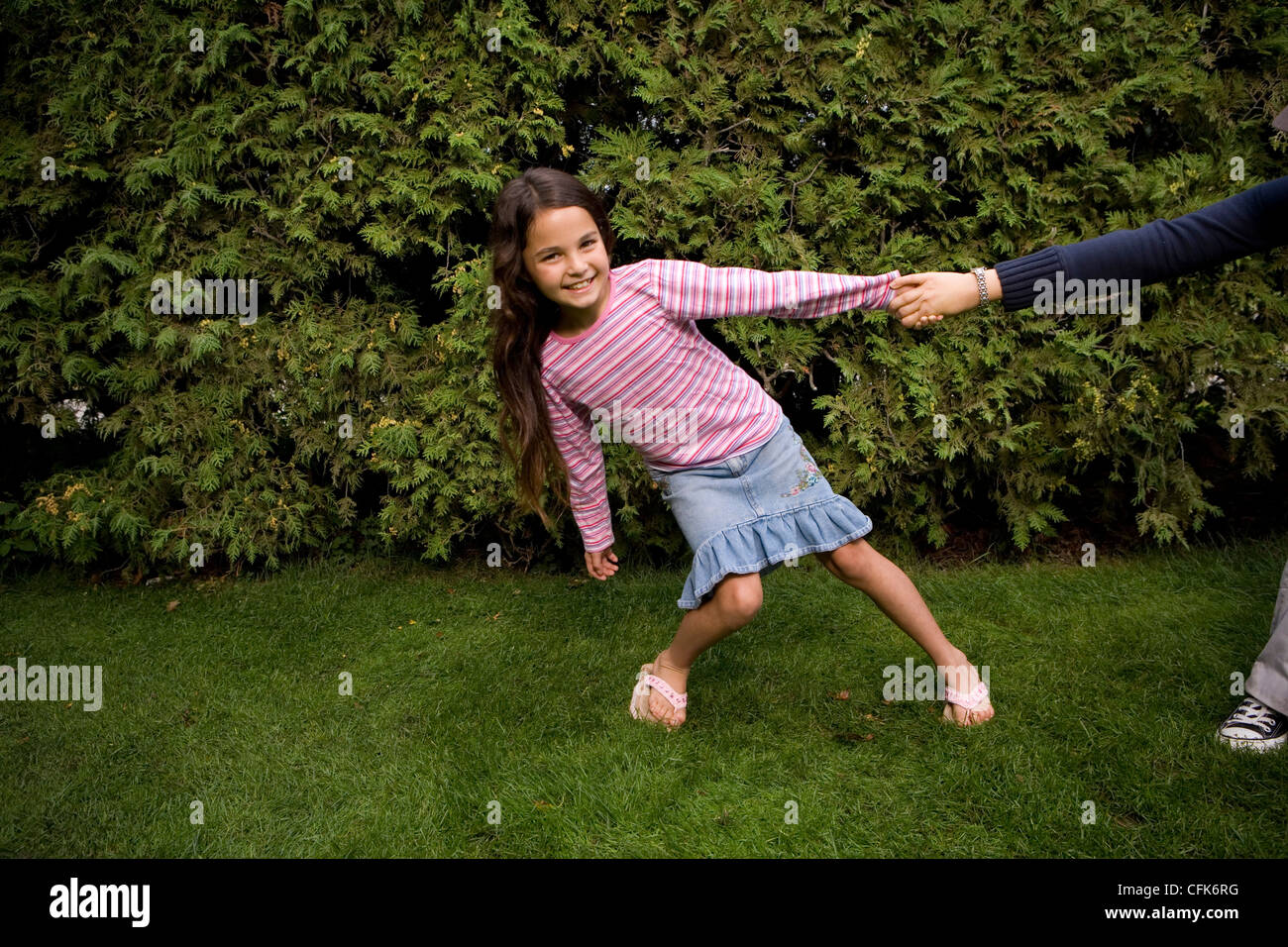 Young Girl Pulling the arm of Unseen Adult Stock Photo Alamy