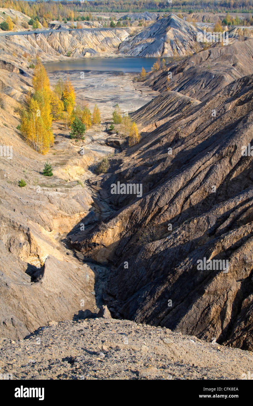 sand canyon with yellow autumn birches and a lake between hills Stock Photo