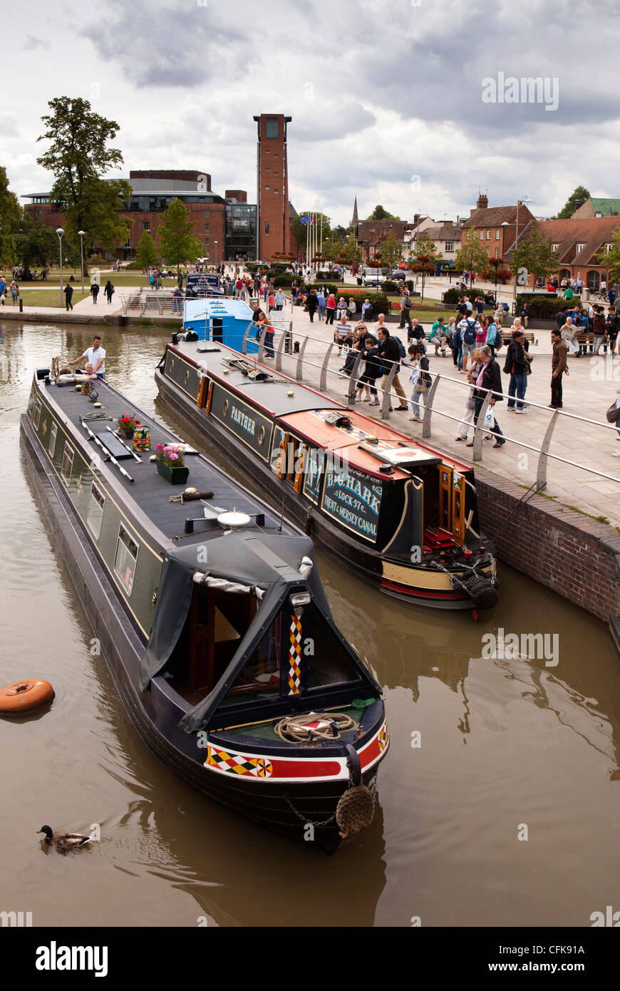 Warwickshire, Stratford on Avon, narrowboats on Canal as it passes Royal Shakespeare Theatre Stock Photo
