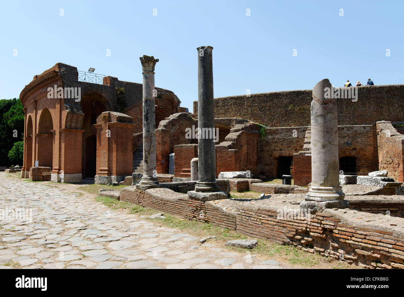 Ostia Antica. Lazio. Italy. View along the basalt stone paved Decumanus Maximus towards the Roman theatre built by Agrippa in Stock Photo