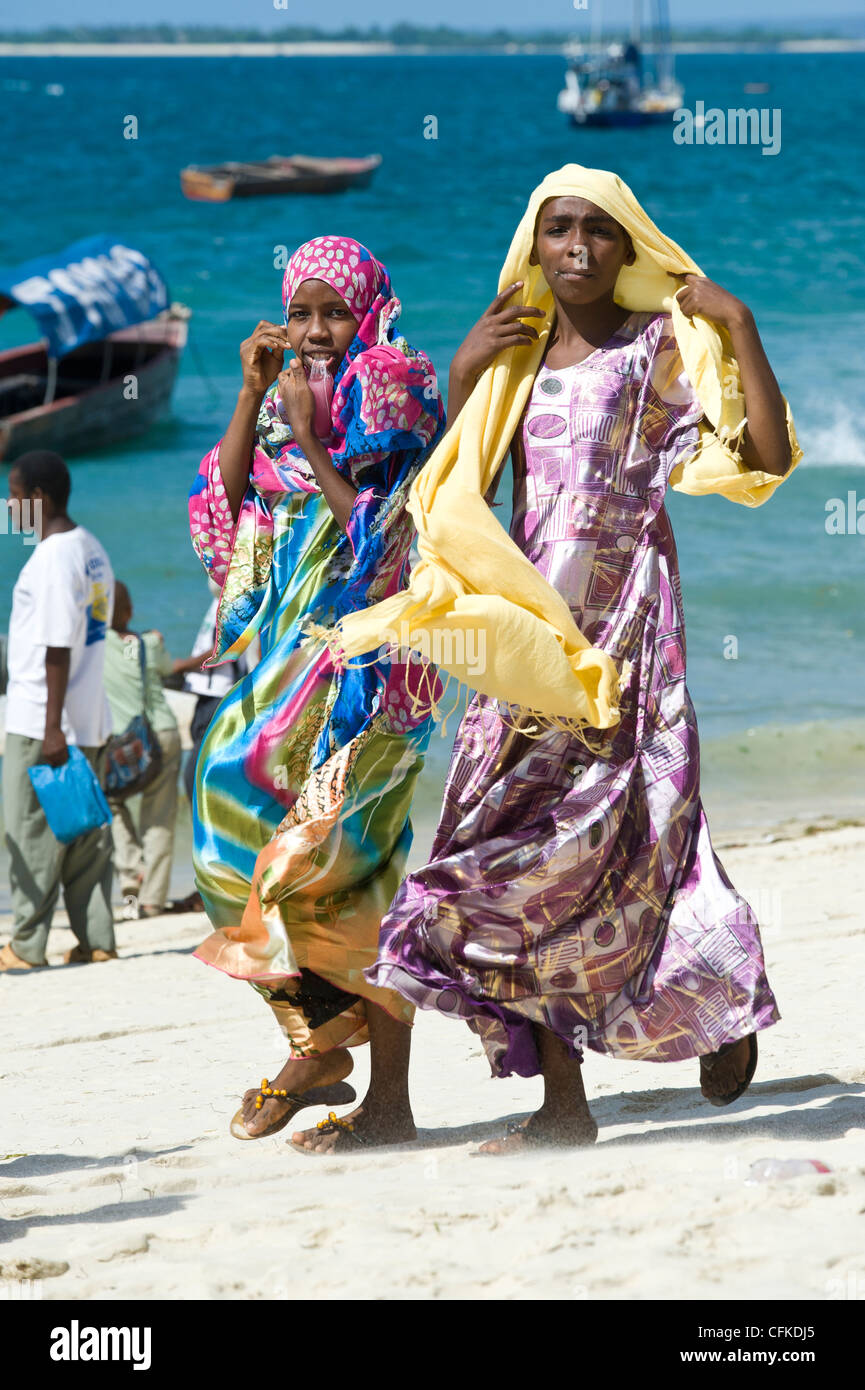 Swahili women in traditional dresses walking on the beach in Stone Town  Zanzibar Tanzania Stock Photo - Alamy