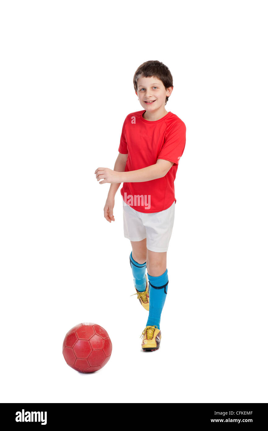 boy kicking a red soccer ball on white background Stock Photo