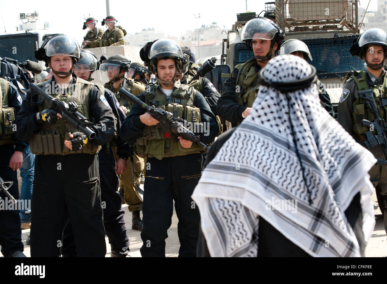 A Palestinian man confronts Israeli soldiers during a demonstration against the Israeli occupation at Kalandia checkpoint. Stock Photo