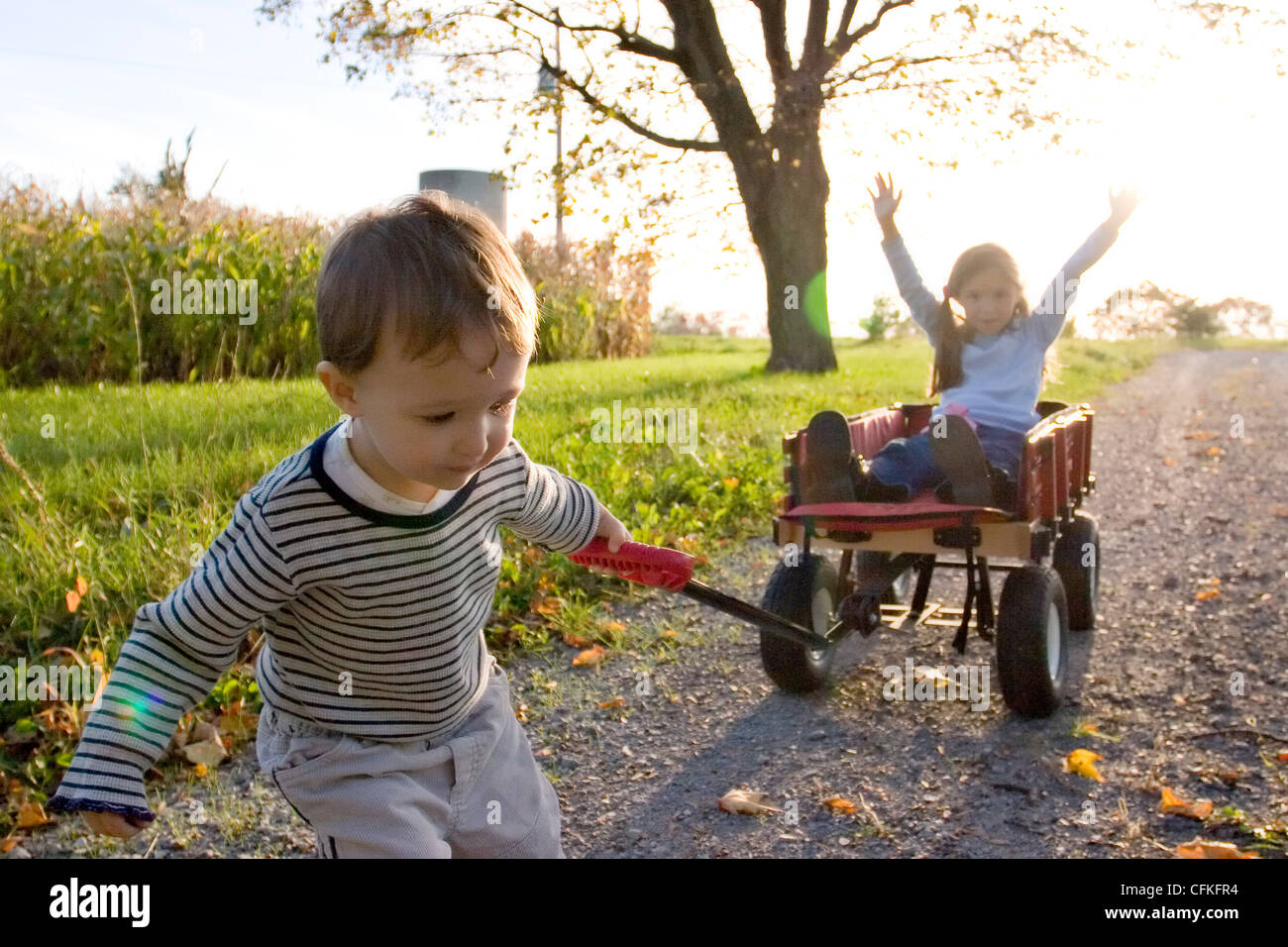 Brother and Sister Playing with Wagon Stock Photo - Alamy