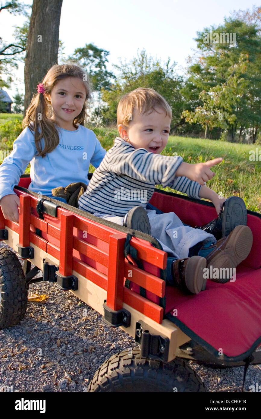 Brother and Sister Playing in Wagon Stock Photo - Alamy