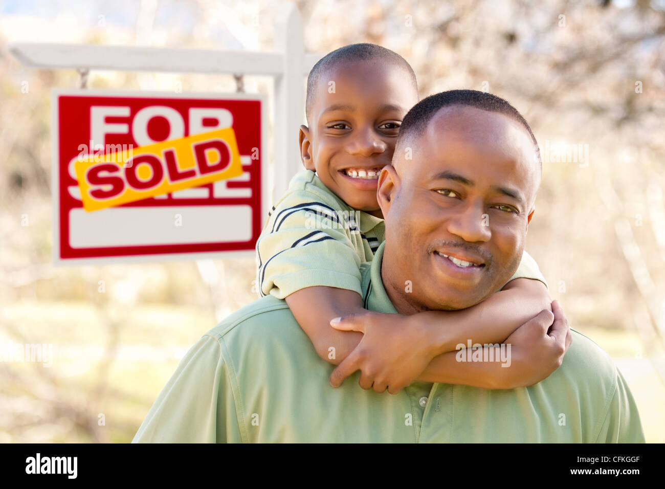Happy African American Father and Son in Front of Sold Real Estate Sign ...
