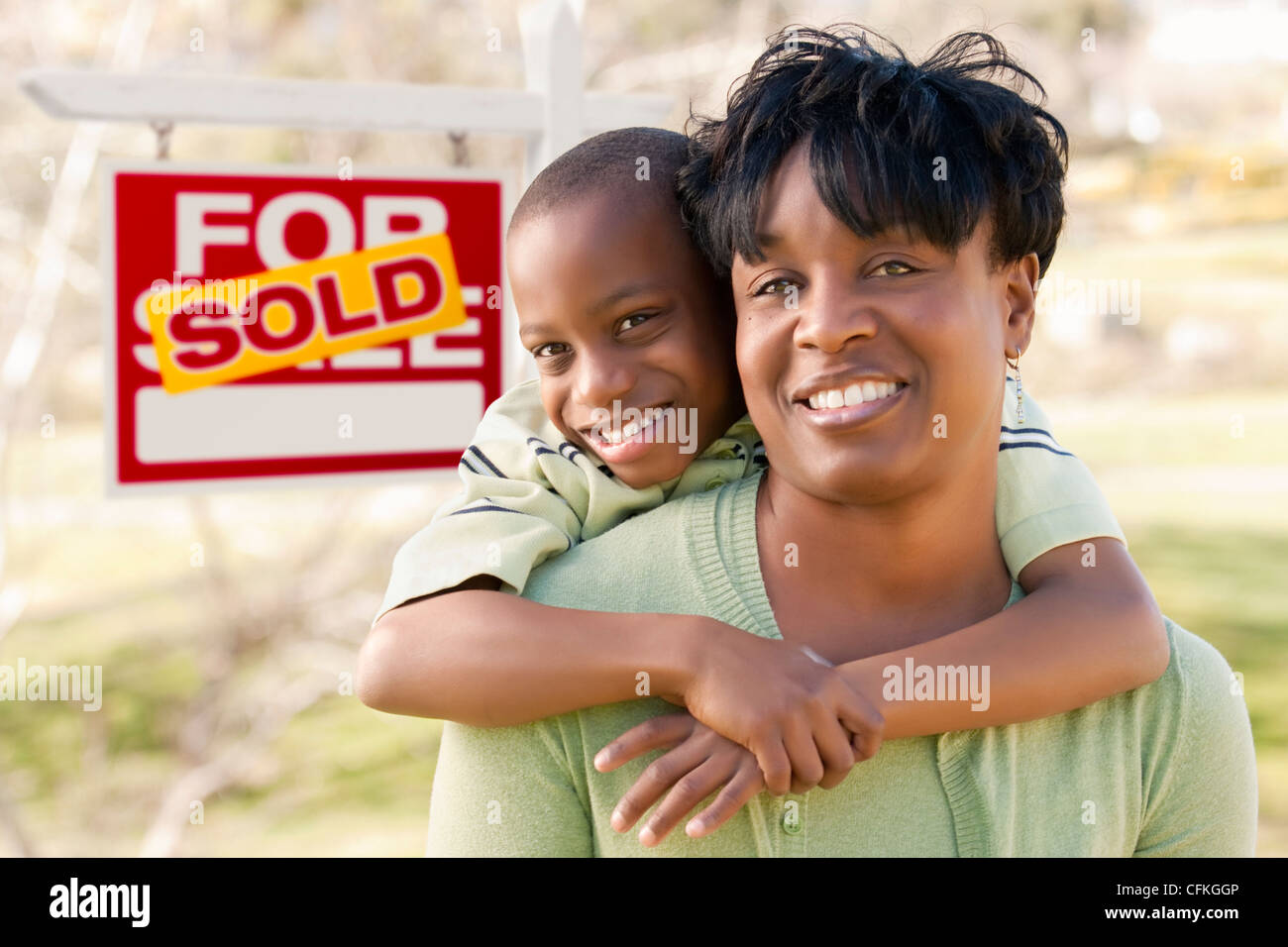 Happy African American Mother and Child In Front of Sold Real Estate ...