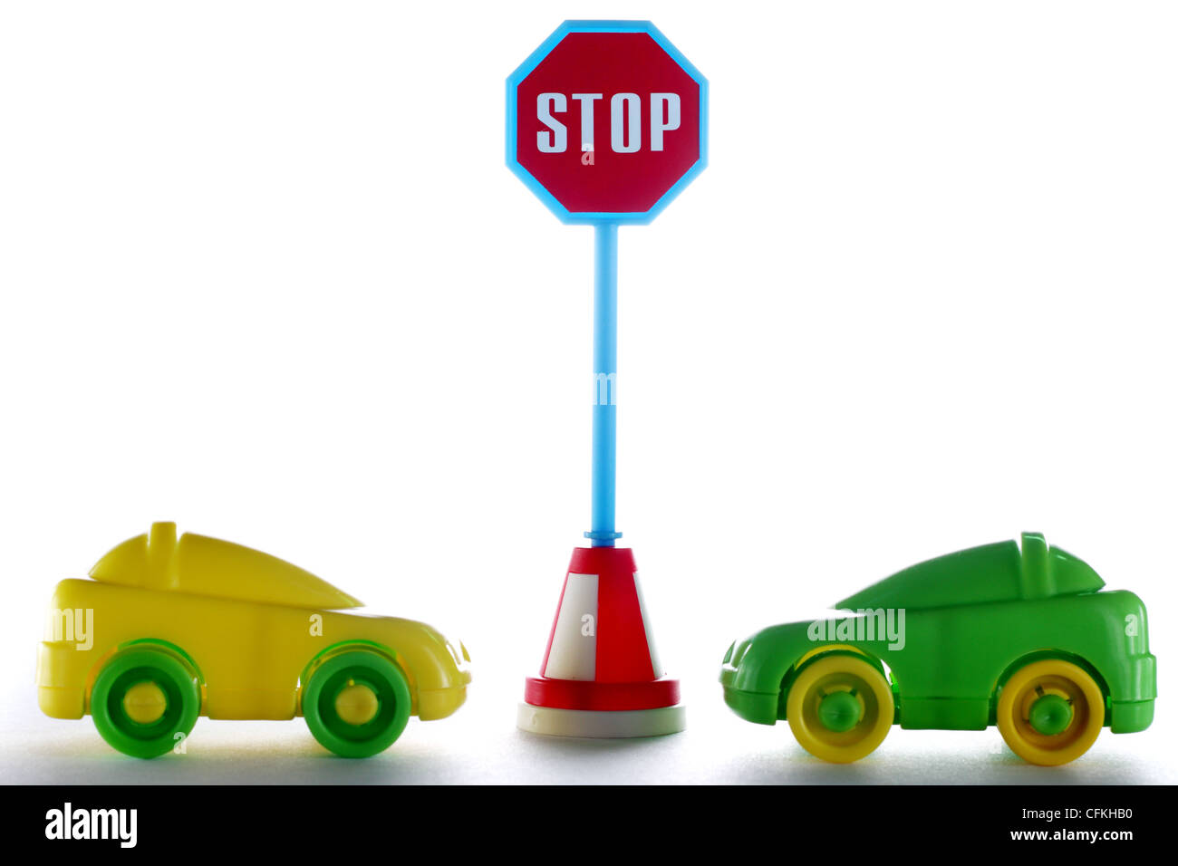 A couple cars behind stop road sign at white background Stock Photo