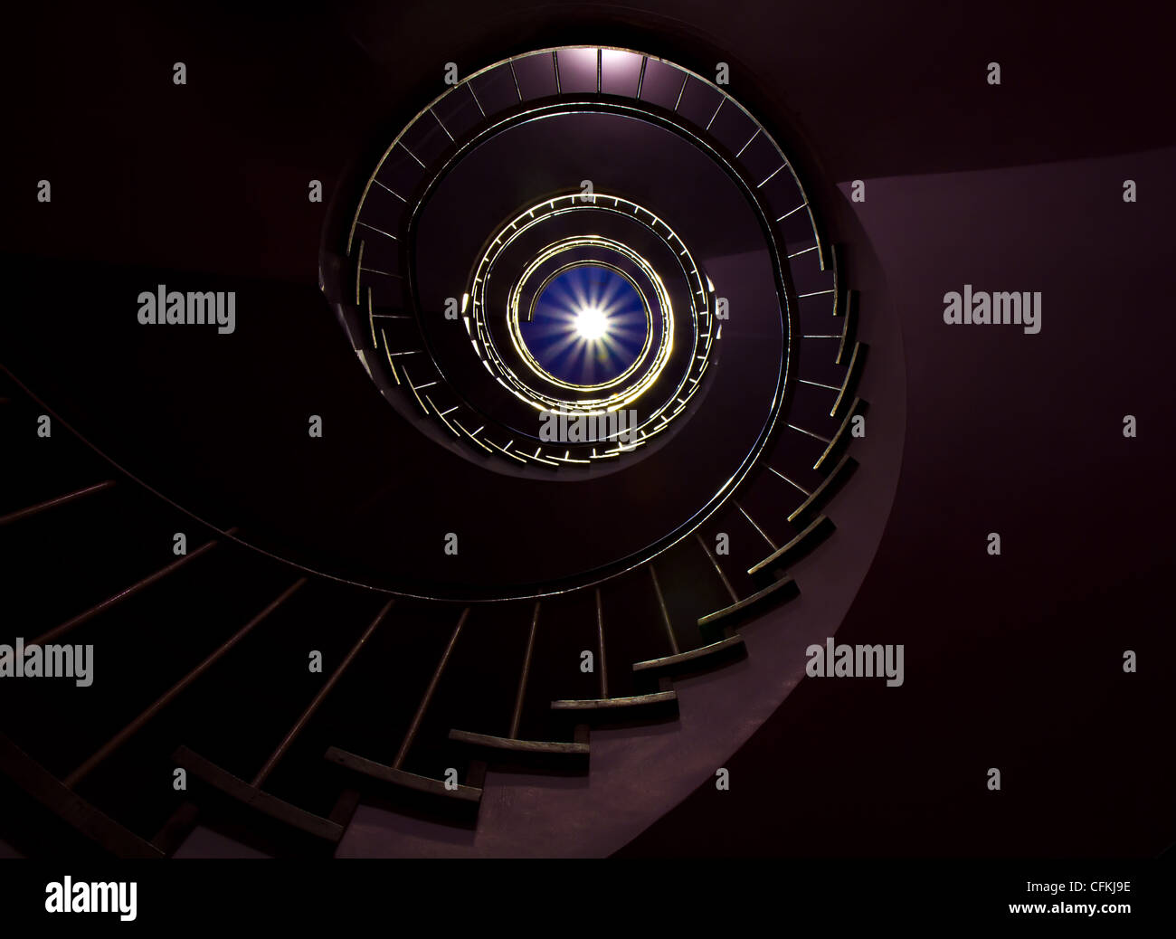 Dark Spiral staircase moving towards the light Stock Photo